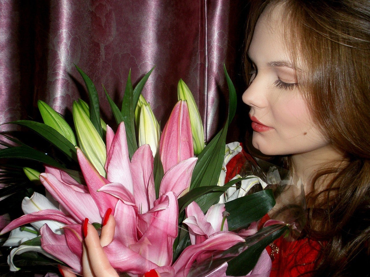 A Woman holding a bouquet of pink lilies