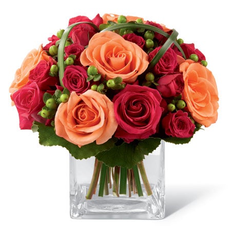 A Bouquet of Hot Pink Roses, Orange Roses, and Red Spray Roses in a Square Clear Vase