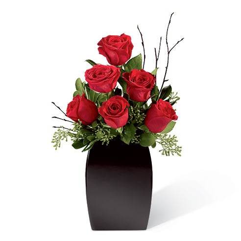 A Bouquet of Red Roses and  Lush Greens with Black Painted Branches in a Black Ceramic Vase