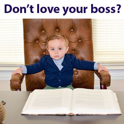 A baby on a giant office luxurious chair with an opened book in front of him
