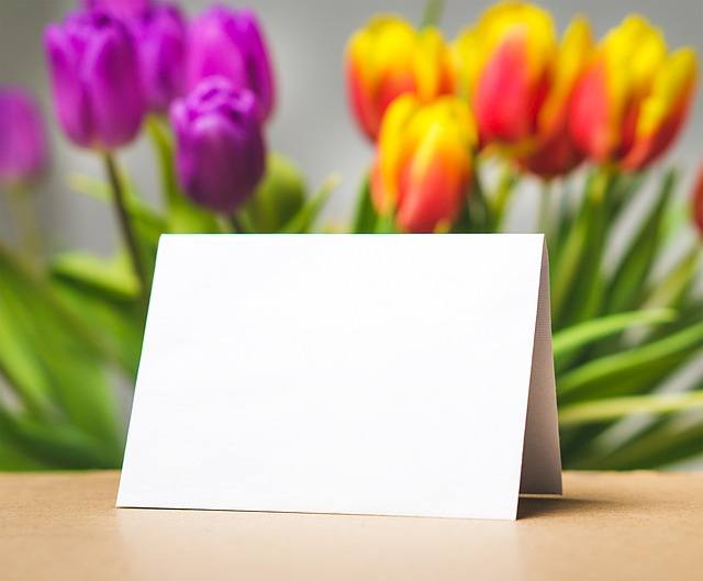 Blank Card at the top of the table with purple and orange tulips on the background