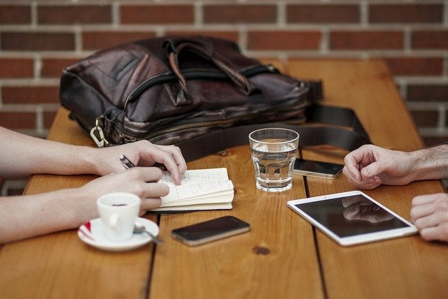 A Coffee Meeting Set up and the other person taking notes