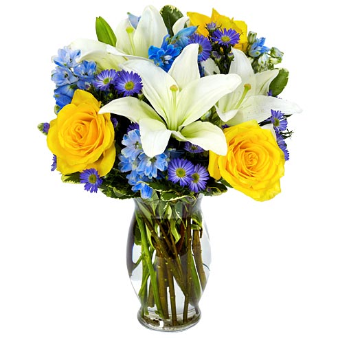 A Bouquet of  White Asiatic Lilies, Yellow Roses, Blue Delphinium and Purple Monte Casino in a Keepsake Glass Vase