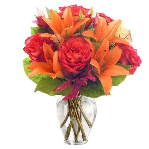 A bouquet of Orange Roses, and Apricot Lilies on a Glass Vase