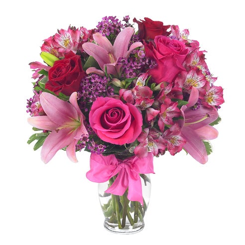 A Bouquet of Red And Pink Roses, Hot-Pink Asiatic Lilies, and Fuchsia Alstroemerias in a Glass Vase with Bow