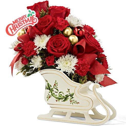 Red roses and white flowers arranged in a sleigh for a christmas gift