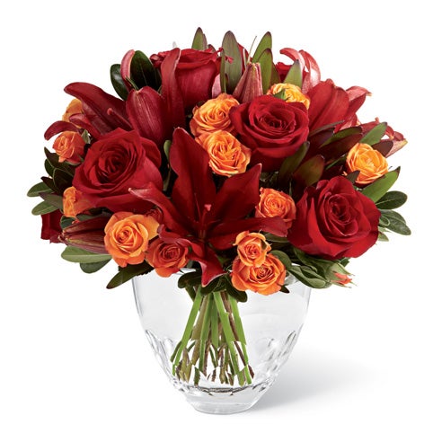 A Bouquet of Red Roses, Orange Spray Roses and Burgundy Lilies in a Modern Glass Vase