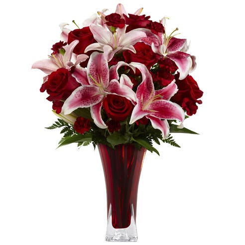 Red stargazer lily red roses and red carnations bouquet in a red glass vase