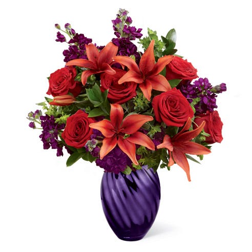 Red asiatic lily and rose flower bouquet in a glass purple vase flower delivery