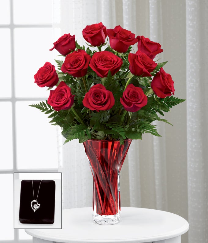 A Bouquet of Red Roses, Burgundy Mini Carnations and Lush Greens in a Stylish Red Glass Vase