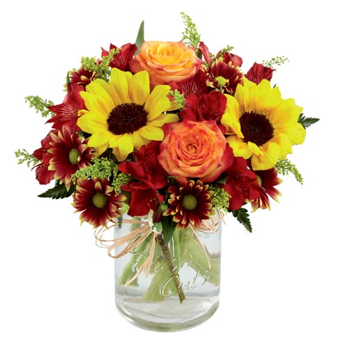 A bouquet of Sunflowers, Orange Roses, Red Peruvian Lilies, Yellow Solidago, Burgundy Daisies and Lush Greens on a glass vase