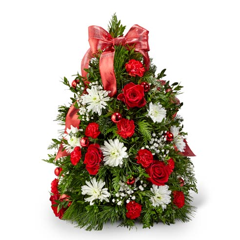 Mini Christmas Tree flower arrangement including Red Roses, Red Mini Carnations, White Cushion Pompons, Gypsophila, Boxwood, and Assorted Christmas Greens with Red Ribbon and Red Mini Ornaments