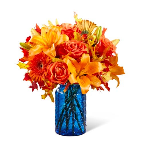 A bouquet of  Orange Roses, Orange LA Hybrid Lilies, Orange Gerbera Daisies, and Orange Carnations on a Blue Vase