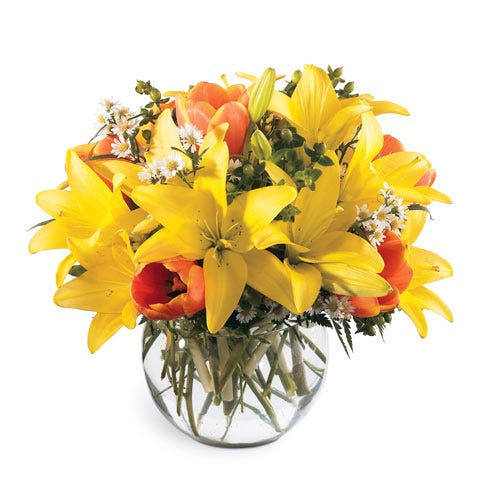 Yellow lily and orange tulip bouquet in a glass bubble bowl