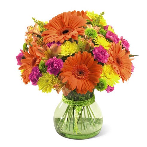 Orange gerbera daisies, yellow poms and pink carnations in green vase
