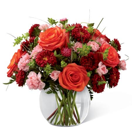 Red matsumoto asters, light pink mini carnations & greens in a circular vase