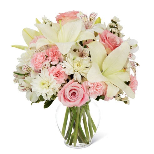 A Bouquet of White Asiatic And Peruvian Lilies, Pink Roses, Pale Chrysanthemums, Statice and Pink Mini Carnations in a Clear Glass Vase