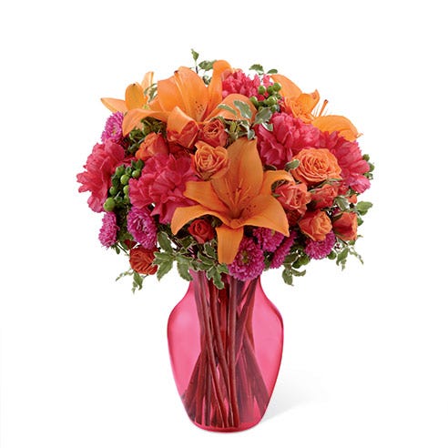 Floral arrangement of orange spray roses, orange Asiatic lilies, hot pink matsumoto asters, fuchsia carnations, and green hypericum berries
