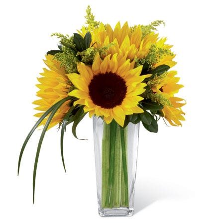 Sunflowers, solidago, and lily grass blades in a clear glass tapered square vase