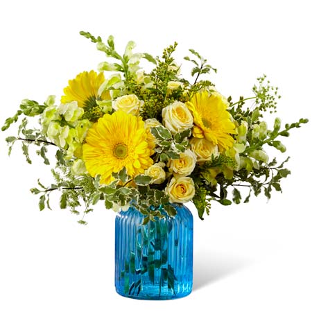 Yellow gerbera daisies paired with yellow spray roses in a blue vase