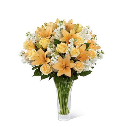 Cream roses, peach lilies, and white stock in a premium flower bouquet