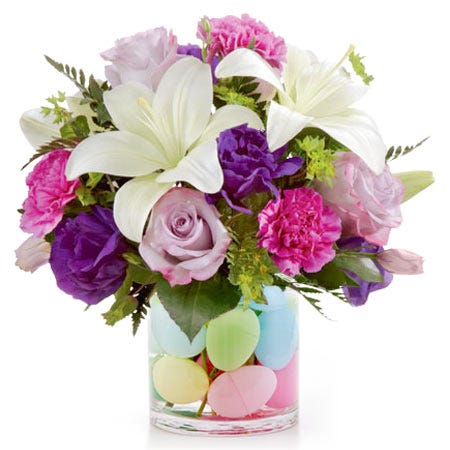 A Bouquet of Lavender Roses, Purple Flowers, Fushia Carnations, and White Asiatic Lilies with Plastic Easter Eggs in a Clear Glass Vase