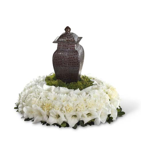 White tabletop funeral flowers wreath with white cushion poms and greens