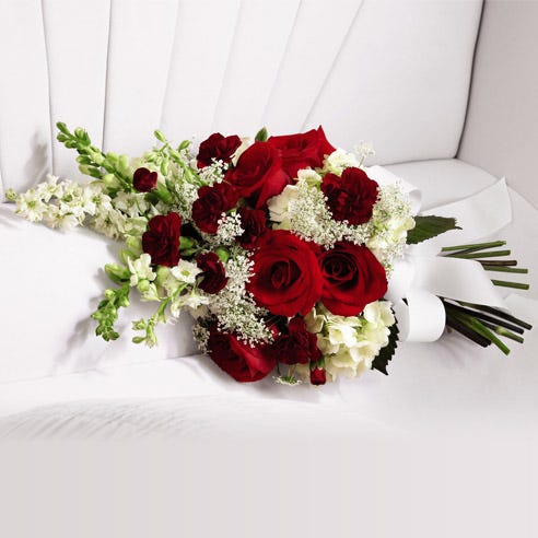 Red roses and white hydrangea casket adornment