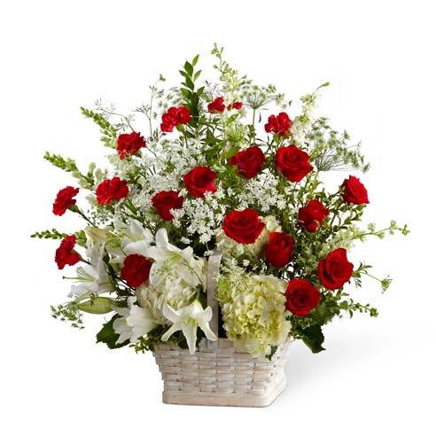 Basket sympathy arrangement with red roses, carnations and white hydrangea
