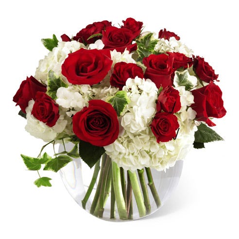 Red roses, white hydrangea and red spray roses in circular glass vase