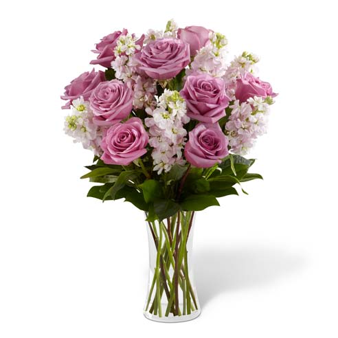 A Bouquet of Purple Roses and Pink Stock in a Keepsake Glass Vase