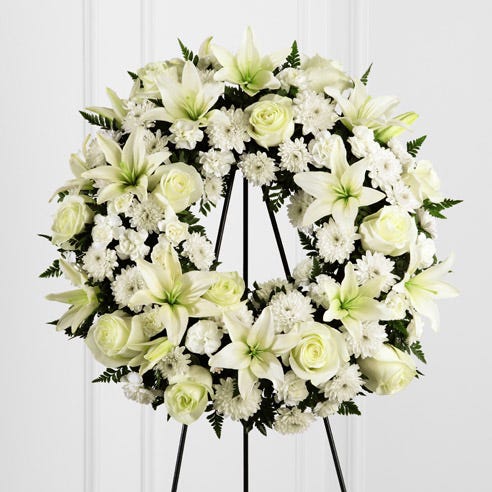 Open center funeral flowers wreath ring standing spray of white roses and lilies