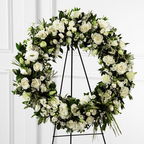 Sympathy white flower wreath standing spray with roses, lisianthus, and freesia