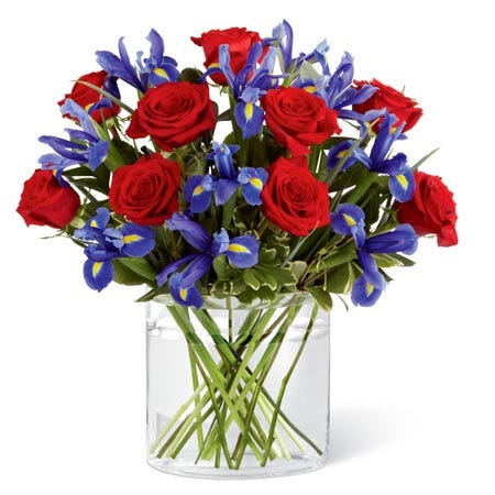 Red roses with purple irises in unique glass vase for cheap flower delivery