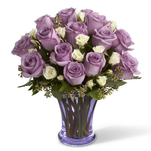 A Bouquet of Purple Roses and White Spray Roses in a purple Glass Vase