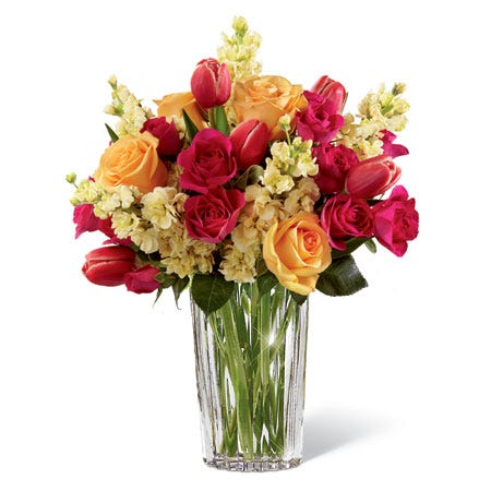 Fuchsia tulips, peach roses and hot pink spray roses in a glass