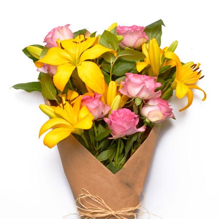 Wrapped yellow lilies and hot pink rose bouquet