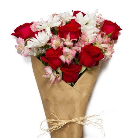 Wrapped flower bouquet with love flowers, red roses and pink alstroemeria