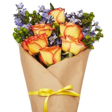 Paper wrapped rustic orange rose bouquet with hypericum berry