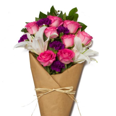 Mixed wrap rose bouquet delivery with pink roses, purple carnations in vase