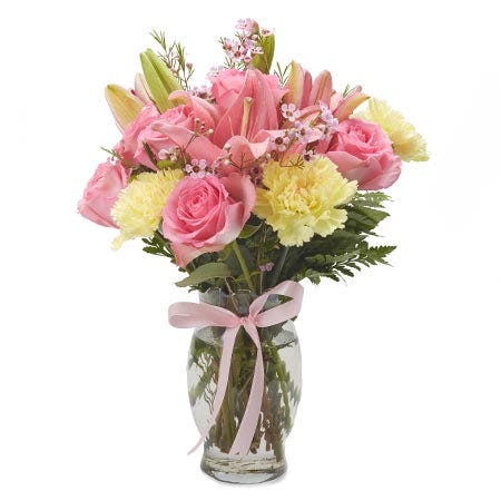 Yellow carnations, light pink roses and yellow carnations in a vase
