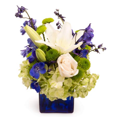 Green hydrangea bouquet with white lily flowers in a vase that's blue