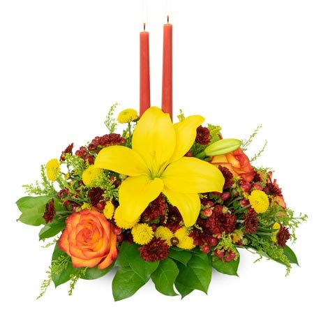Yellow lily flower and candle centerpiece with two orange candles