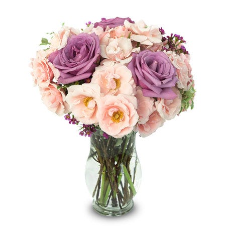 Purple roses and pink spray roses in a glass vase