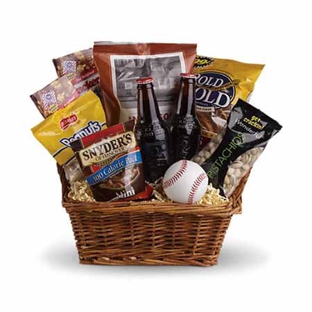 A basket of pistachios, pretzels, boxes of cracker jacks, peanuts and root beer bottles with a baseball