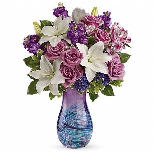 Luxury purple rose and white lily bouquet in a swirl purple and blue glass vase