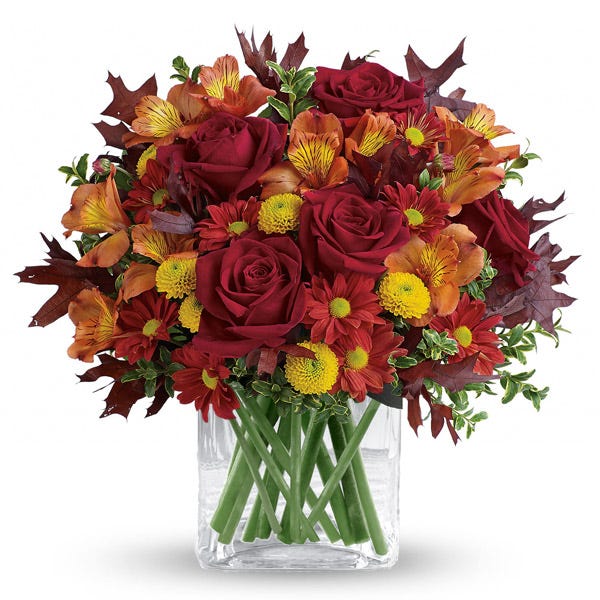 Fall red roses and yellow poms mixed fall flowers bouquet in a clear cube vase