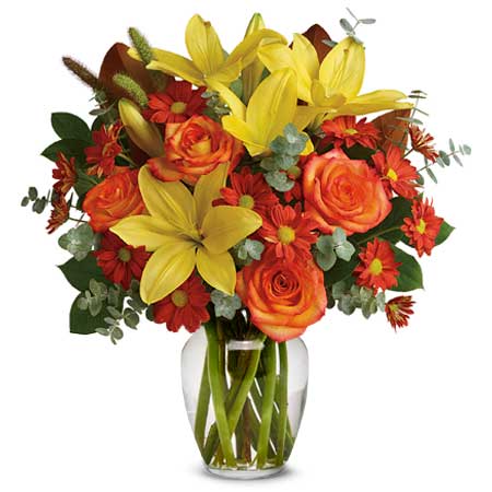 A Bouquet of Yellow Asiatic Lilies, Red Daisy Spray Chrysanthemums, Orange Roses, Millet, Magnolia Leaves, Spiral Eucalyptus, and Lemon Leaf in a Clear Glass Vase with Card Message