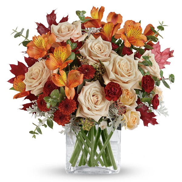 Fall peach roses bouquet in a cube vase with orange alsroemeria