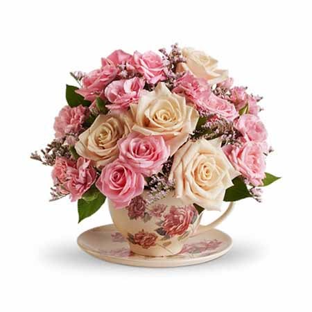 A Bouquet of  Pink Spray And Creme Roses, Light-Pink Mini Carnations and Limonium in a Teacup & Saucer